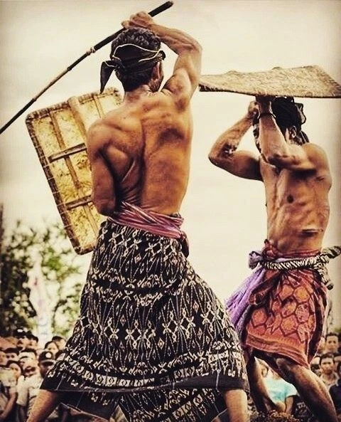 Two Sasak fighters from Lombok in woven sarongs with rattan shields during a Peresean stick-fighting ritual